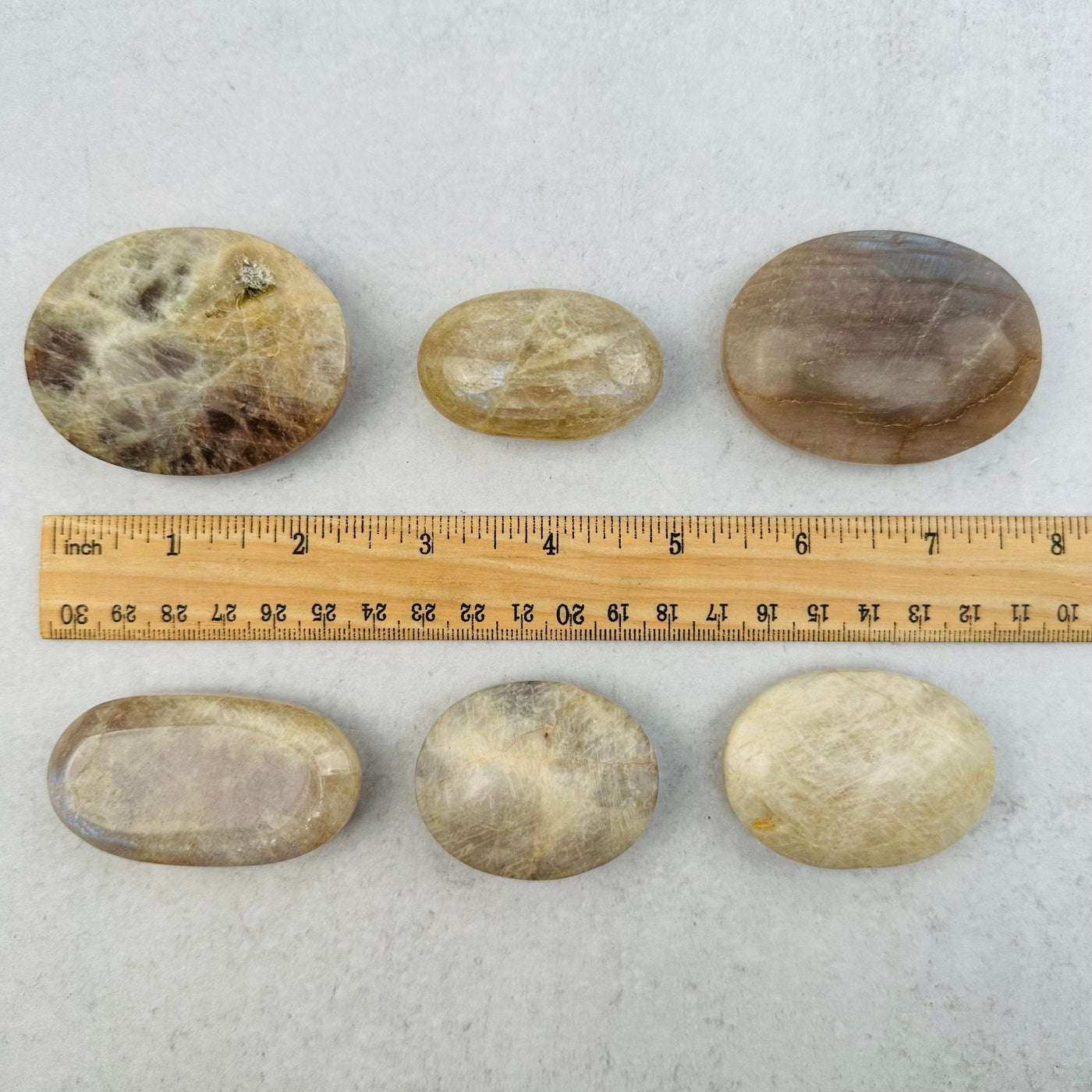 palm stones next to a ruler for size reference 