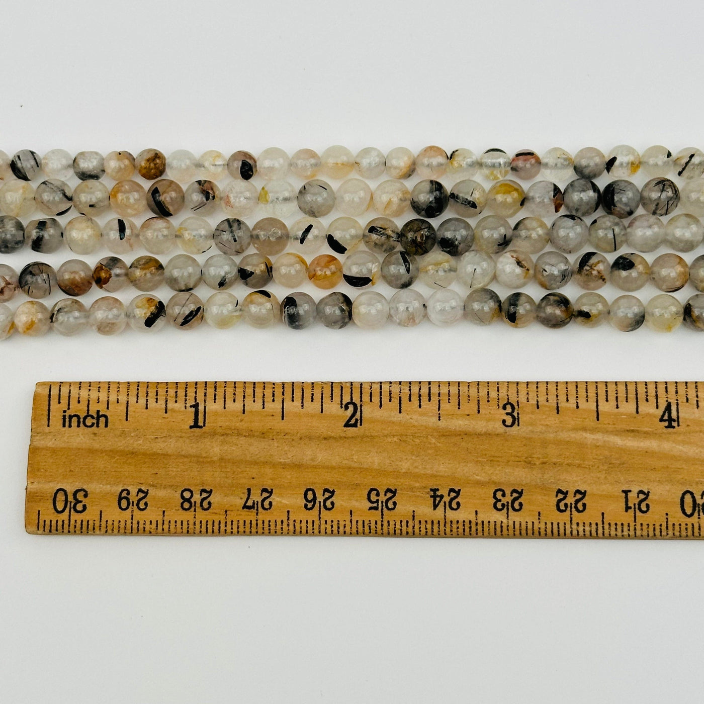 beads displayed next to a ruler for size reference 