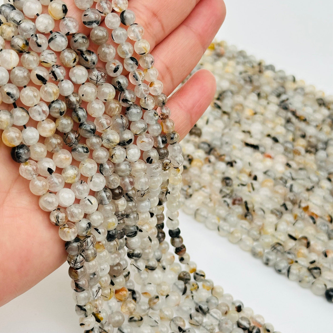 Natural Black Tourmaline Rutilated Crystal Quartz Bead Strands on hand for size reference  