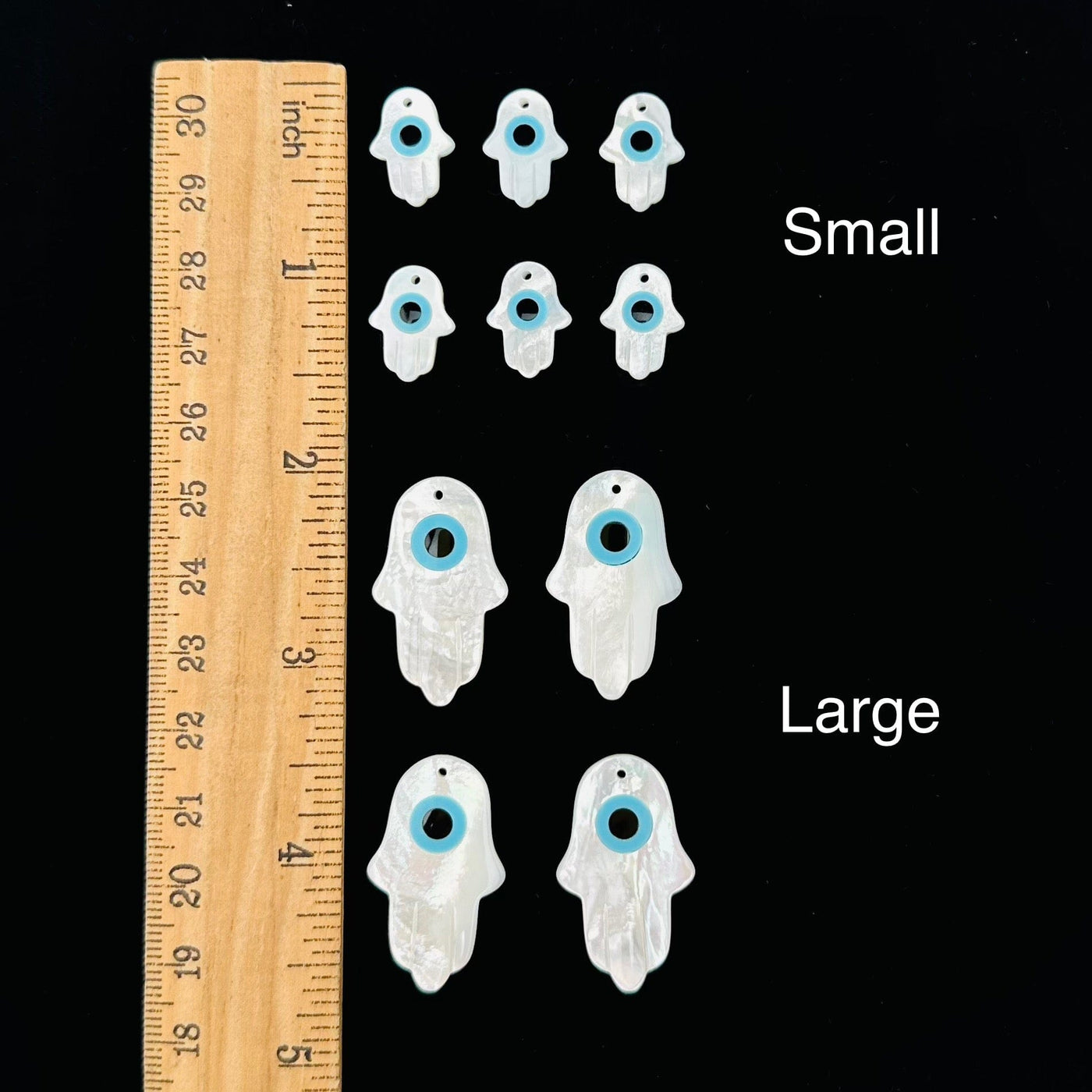 Mother of Pearl Hamsa Hand Eye Drilled Charms displayed next to a ruler for size reference 