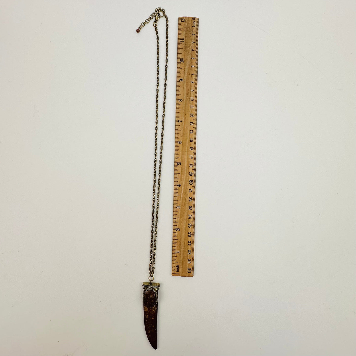 necklace displayed next to a ruler for size reference 