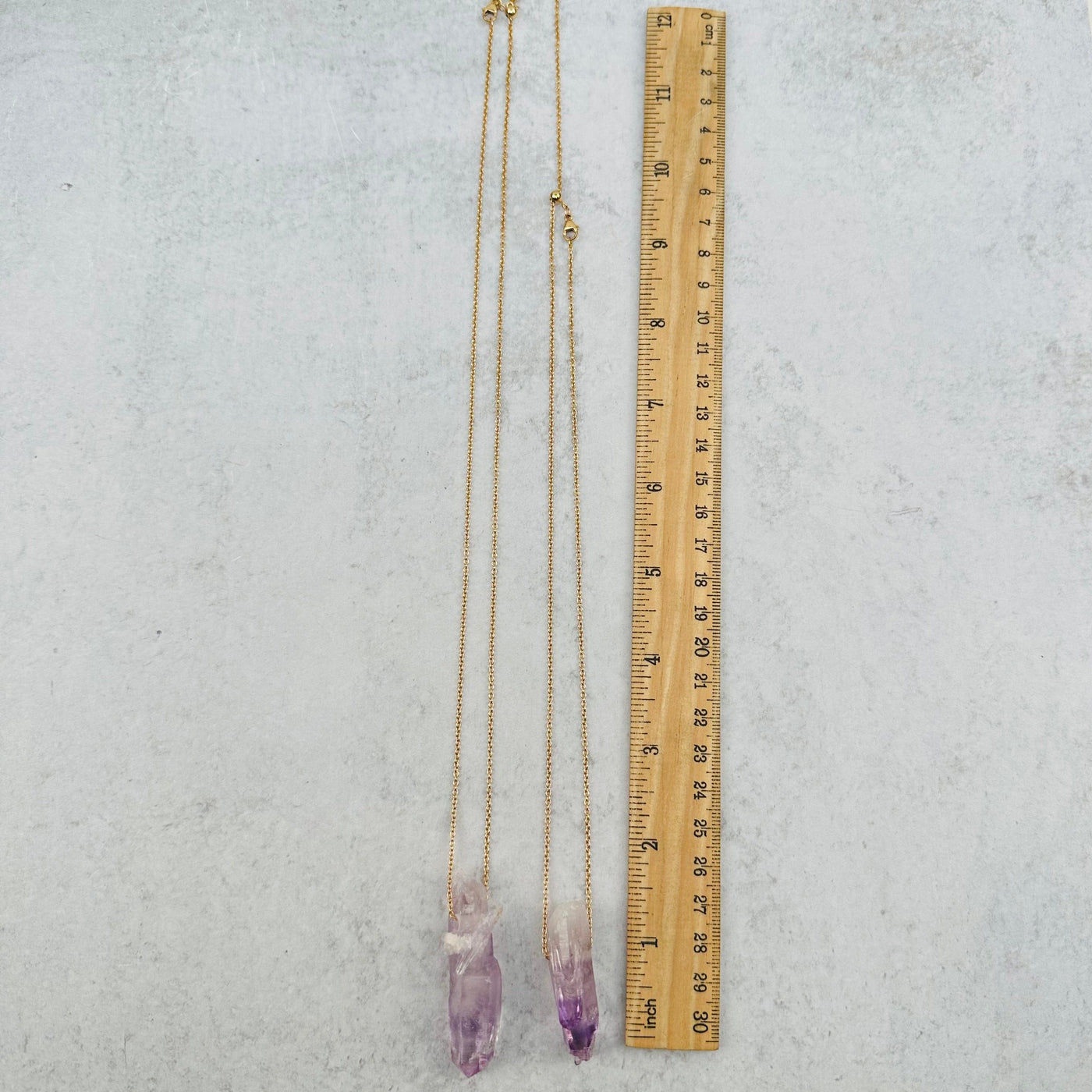 necklace and pendant next to a ruler for size reference 