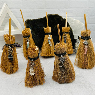multiple brooms displayed to show the differences in the gemstones and charms 