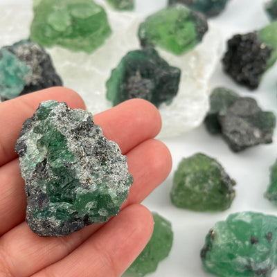 fluorite crystal cluster in hand for size reference 
