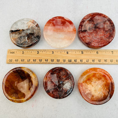 Fire Quartz Sphere Stands next to a ruler for size reference 