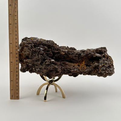 crystal on stand displayed next to a ruler for size reference 