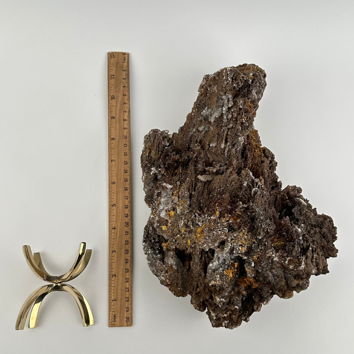 crystal cluster and stand stand displayed next to a ruler for size reference 