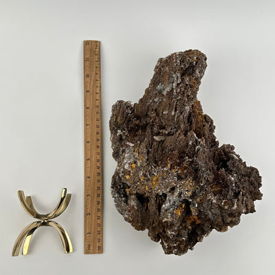 crystal cluster and stand stand displayed next to a ruler for size reference 