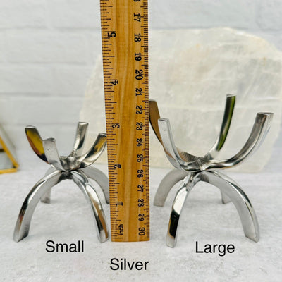 aluminum sphere holder next to a ruler for size reference