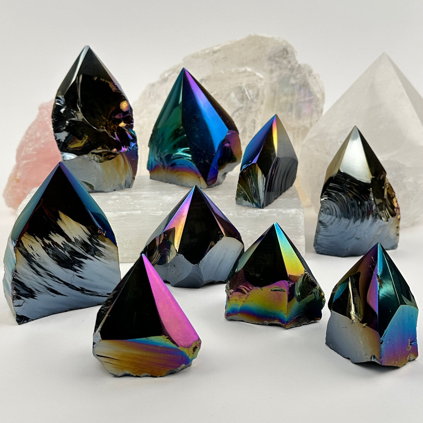 multiple Rainbow Titanium Black Obsidian Crystal Semi Polished Points displayed to show the differences in the sizes and color shades 