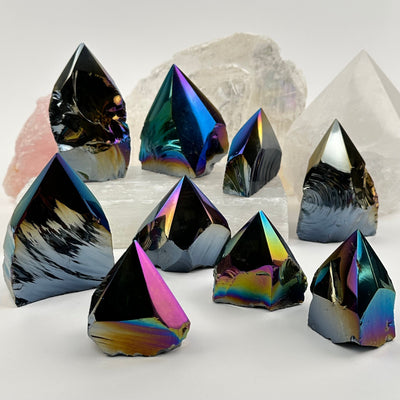 multiple Rainbow Titanium Black Obsidian Crystal Semi Polished Points displayed to show the differences in the sizes and color shades 