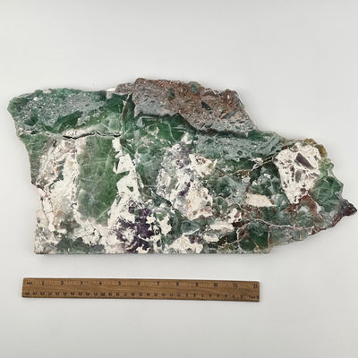 crystal slab displayed next to a ruler for size reference 