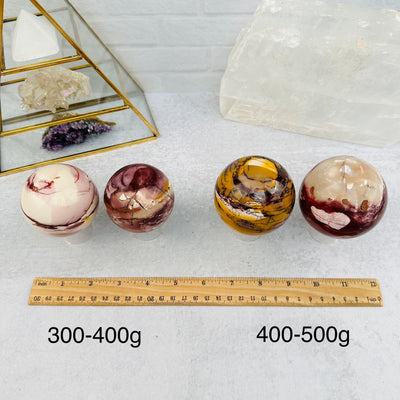 Mookaite Polished Spheres - By Weight - next to a ruler for size reference