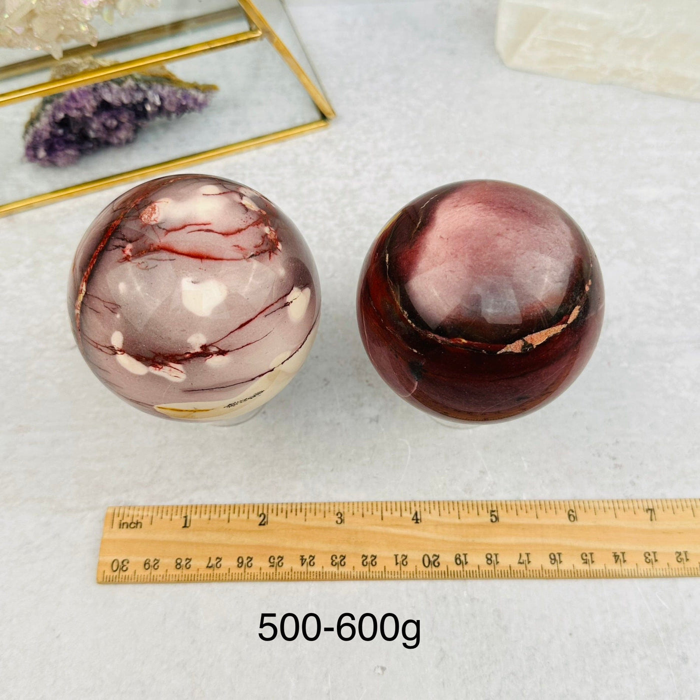 Mookaite Polished Spheres - By Weight - next to a ruler for size reference 