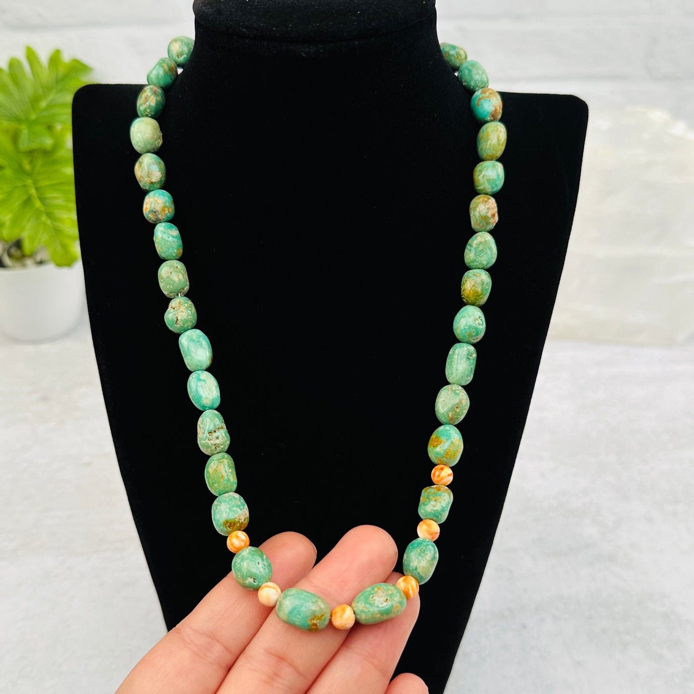 Turquoise Crystal Necklace in hand for size reference 