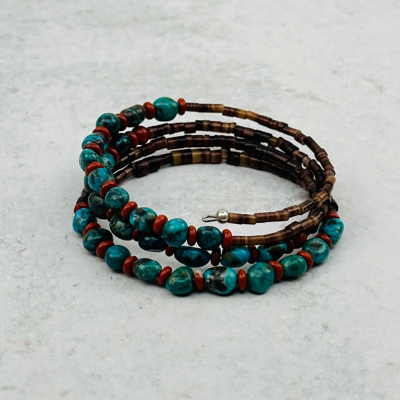 turquoise bracelet with puka shells on gray background