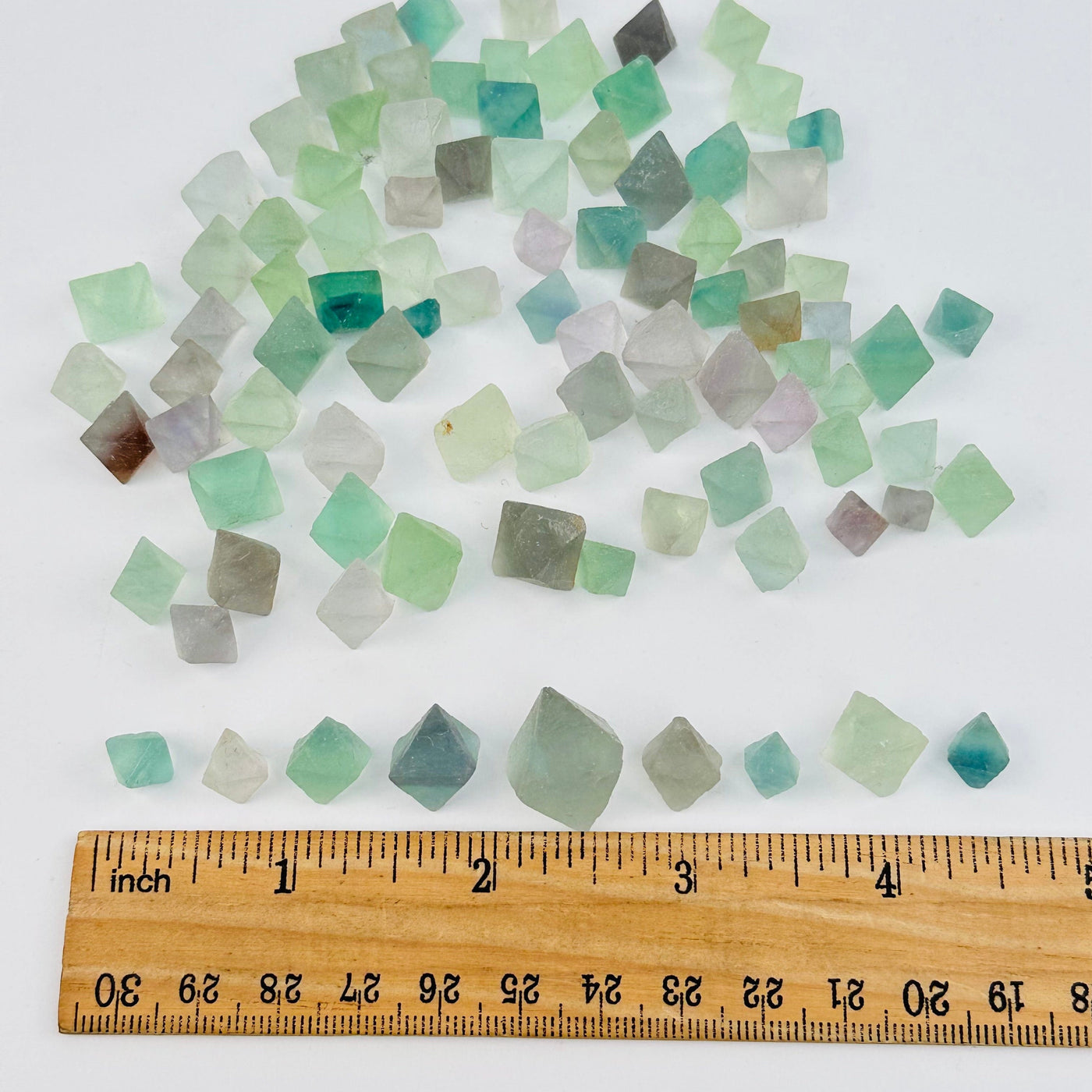 crystals next to a ruler for size reference 