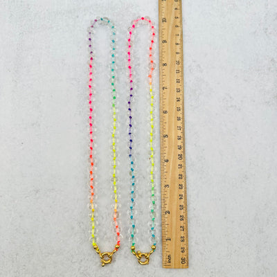 necklaces displayed next to a ruler for size reference 