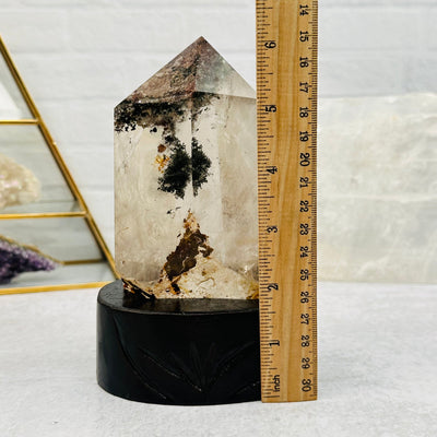 Lodolite Crystal Quartz on Wooden Stand next to a ruler for size reference 