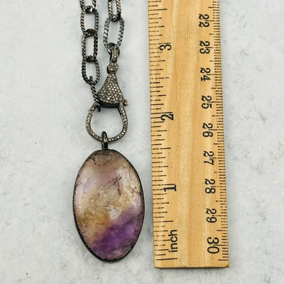 pendant and clasp next to a ruler for size reference 