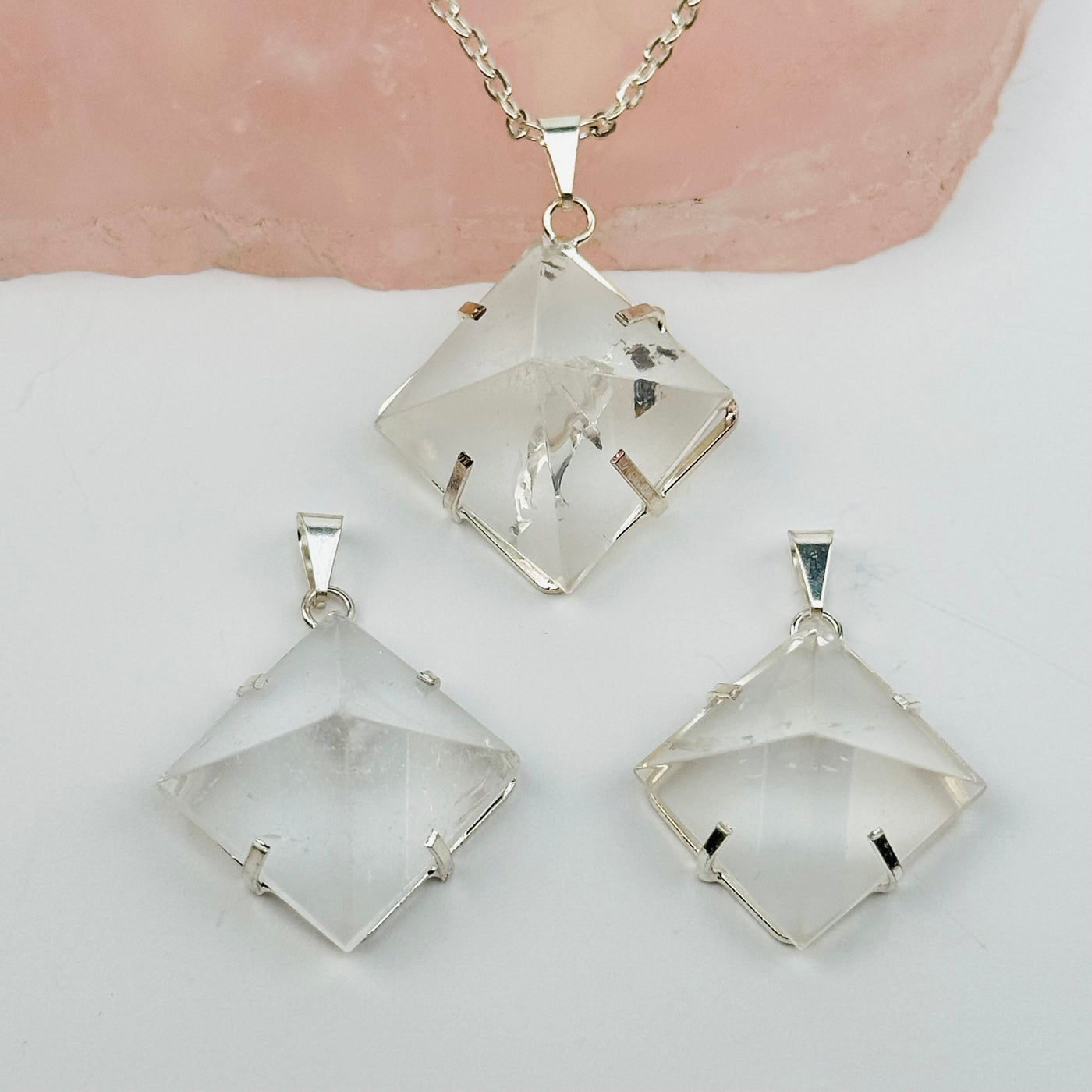 Crystal Quartz Pyramid Pendants displayed to show the differences in the sizes 