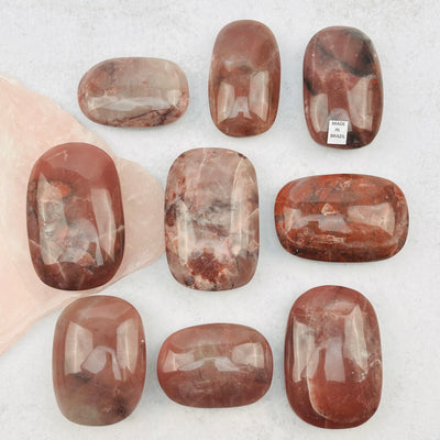 multiple palm stones displayed to show the differences in the color shades and sizes 