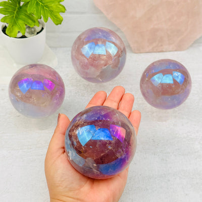 Angel Aura Amethyst Polished Spheres - Crystal Ball in hand for size reference 
