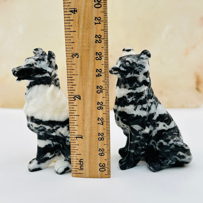 zebra jasper carved crystal dogs next to a ruler for size reference 