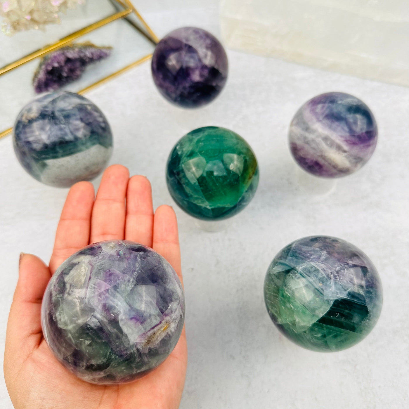 Rainbow Fluorite Sphere in hand for size reference 