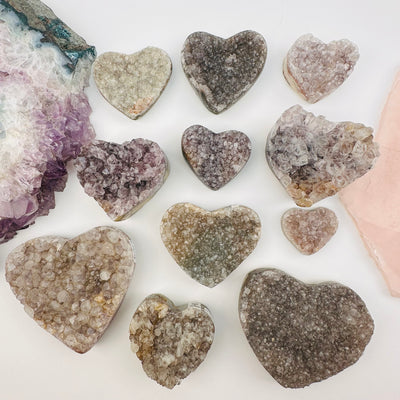 multiple amethyst hearts displayed to show the differences in the sizes and color shades 