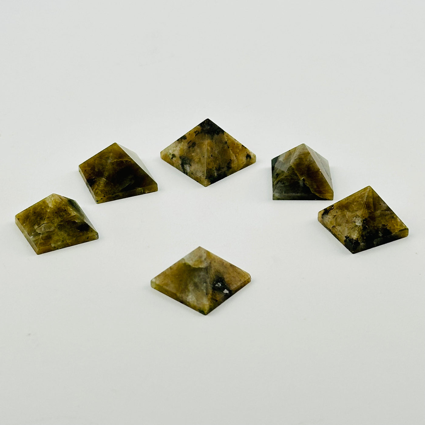 multiple labradorite pyramids displayed to show the differences in the color shades and shapes 