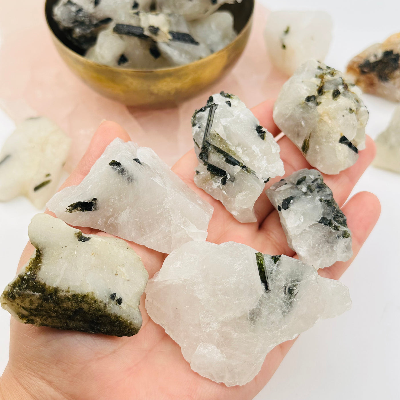 green tourmaline crystals in hand for size reference 