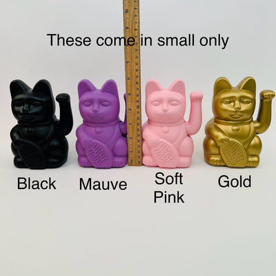 lucky cats displayed next to a ruler for size reference 