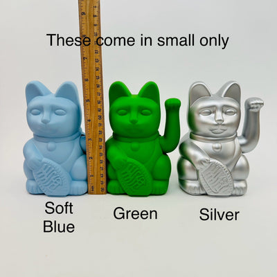 lucky cats displayed next to a ruler for size reference 