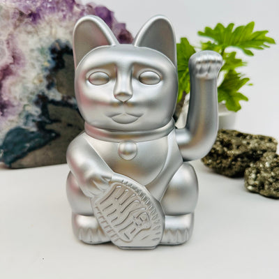 silver colored lucky cat displayed as home decor 