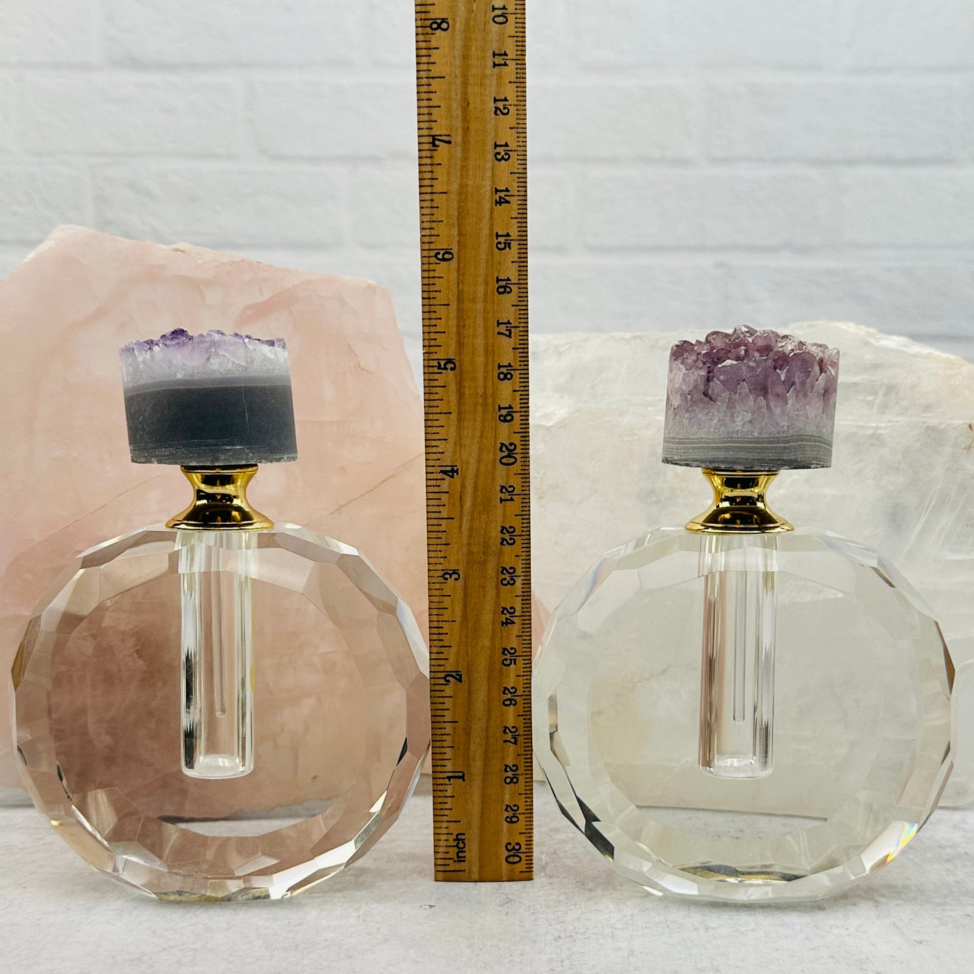 perfume bottles displayed next to a ruler for size reference 