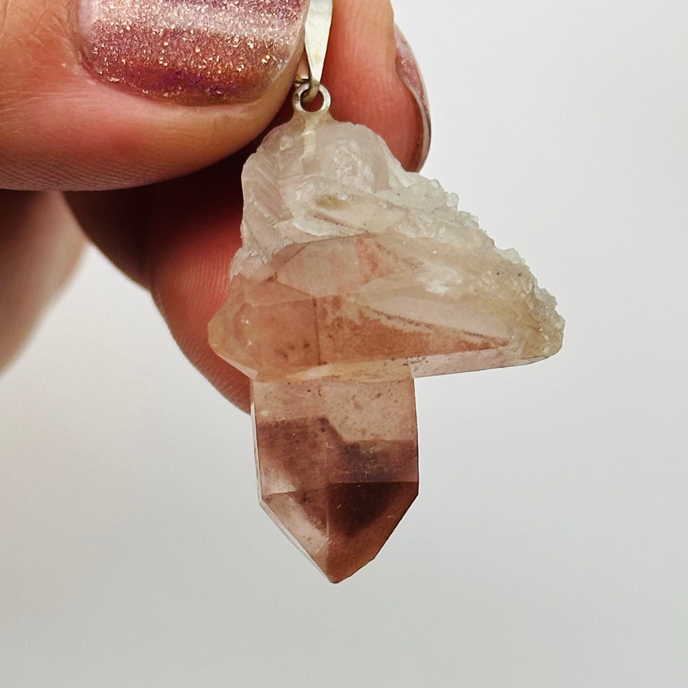 hand holding up lithium quartz pendant