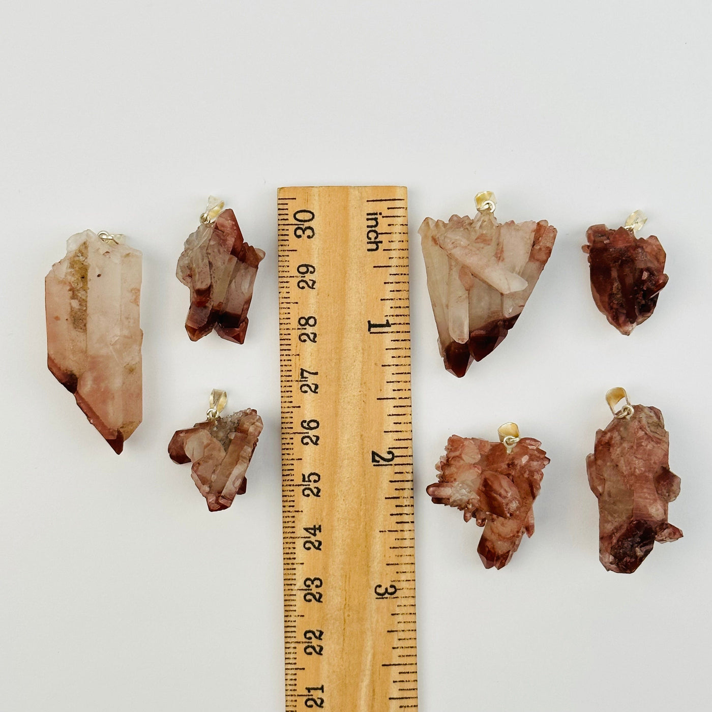 lithium quartz pendants next to a ruler for size reference