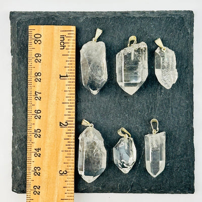 crystal pendants next to a ruler for size reference 