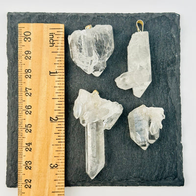 crystal pedants next to a ruler for size reference 