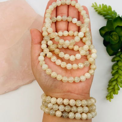 cream moonstone crystal bracelet in hand for size reference 