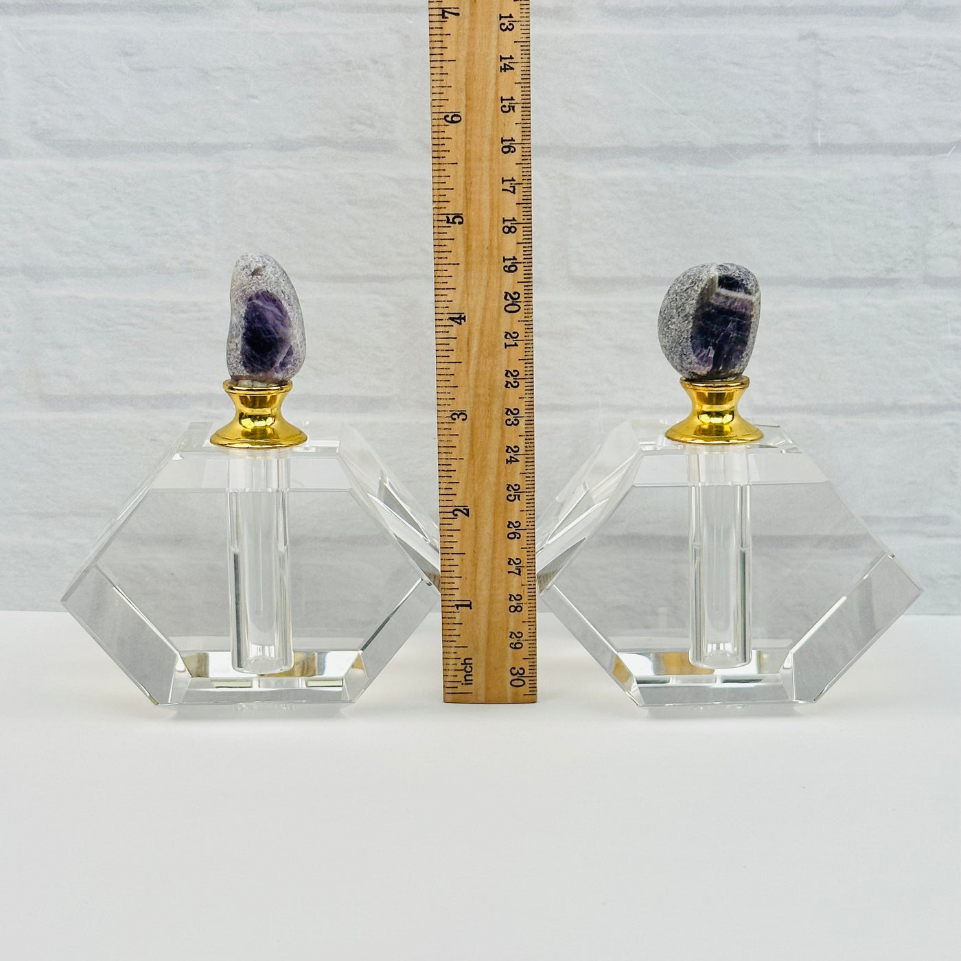 perfume bottles next to a ruler for size reference 