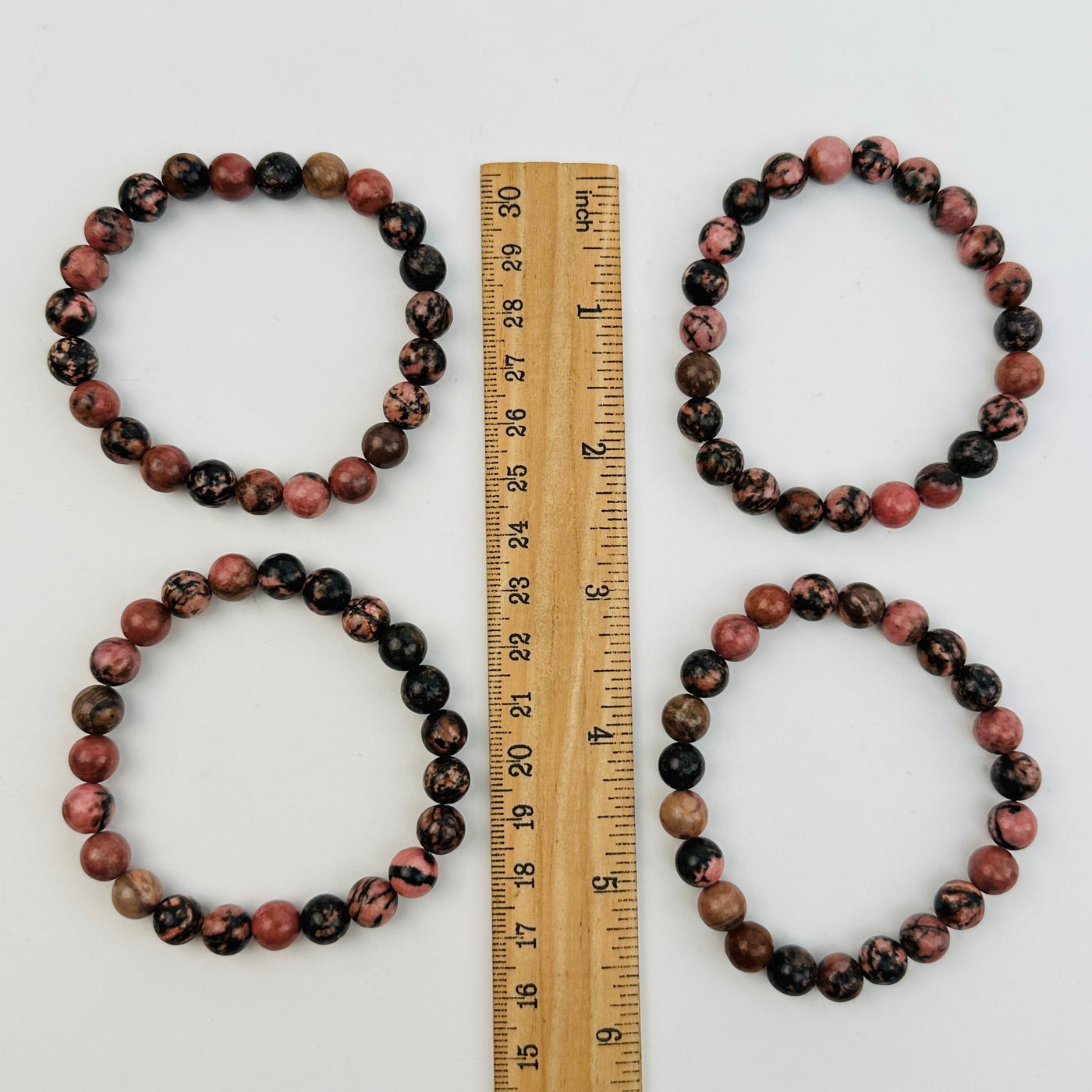 bracelets next to a ruler for size reference 