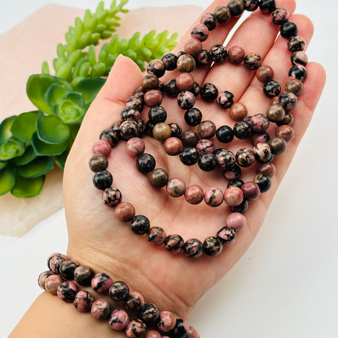 rhodonite bracelets in hand for size reference 