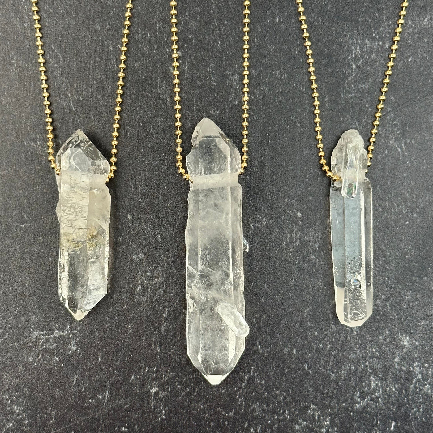 multiple pendants displayed on a necklace chain to show how it hangs 