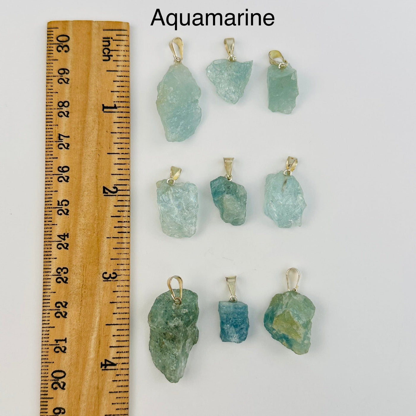 aquamarine pendants next to a ruler for size reference 