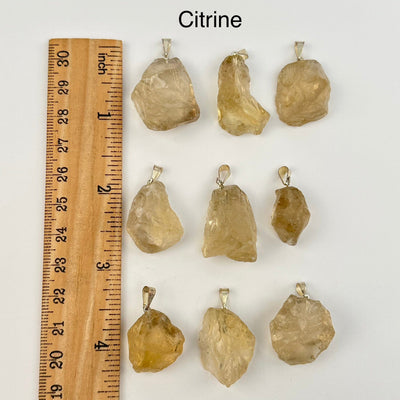 citrine pendants next to a ruler for size reference 