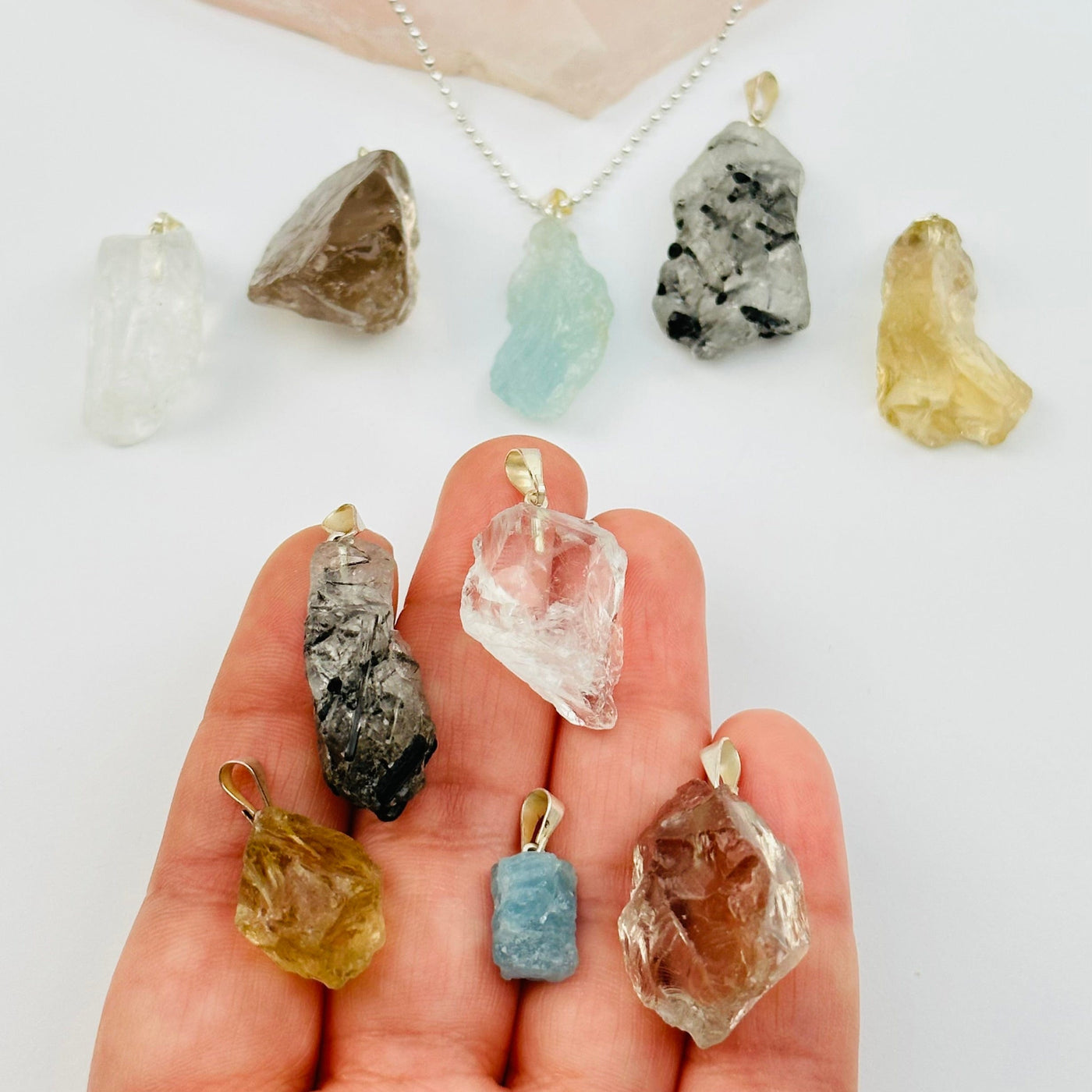 Rough Natural Crystal Stone Pendants in hand for size reference 