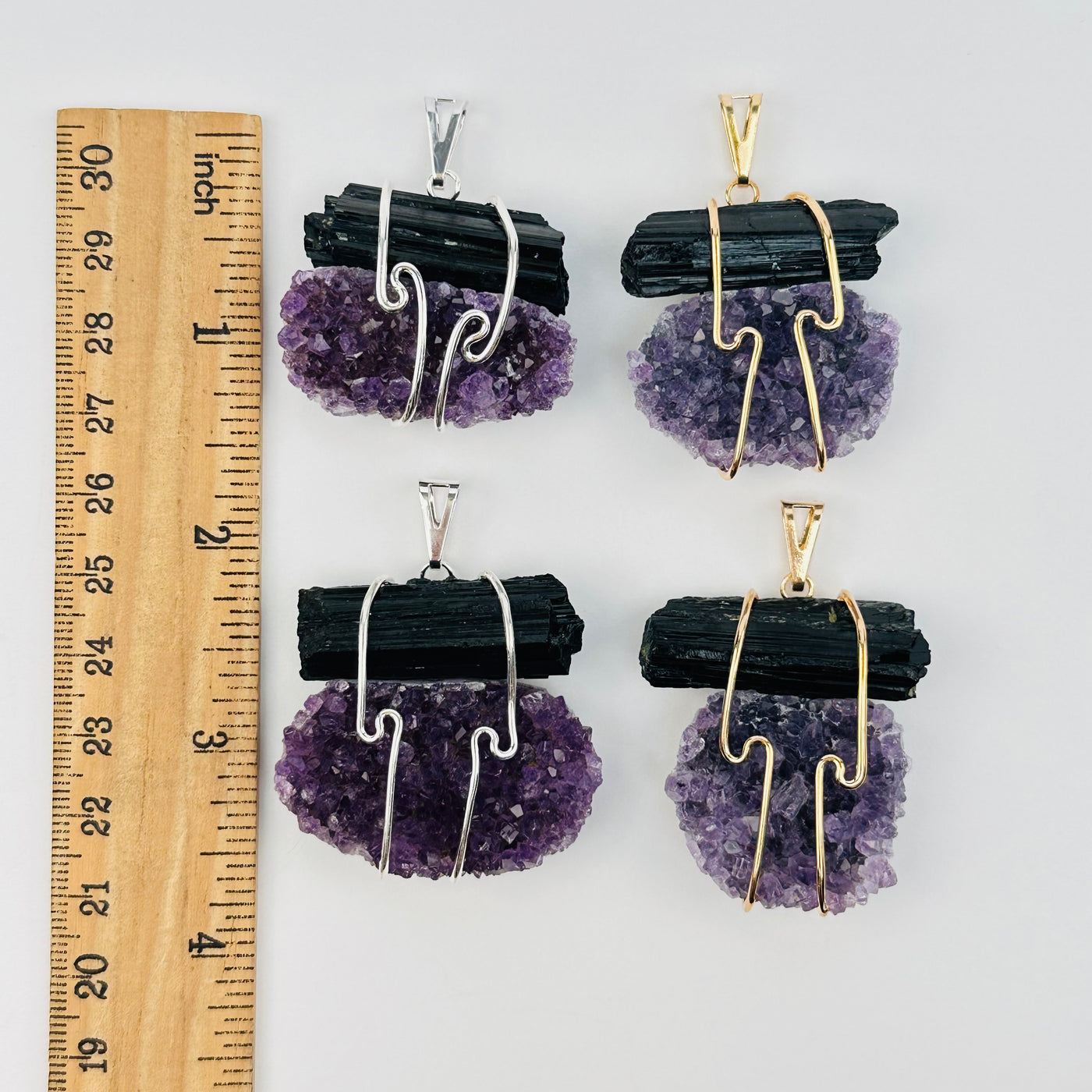 pendants next to a ruler for size references 