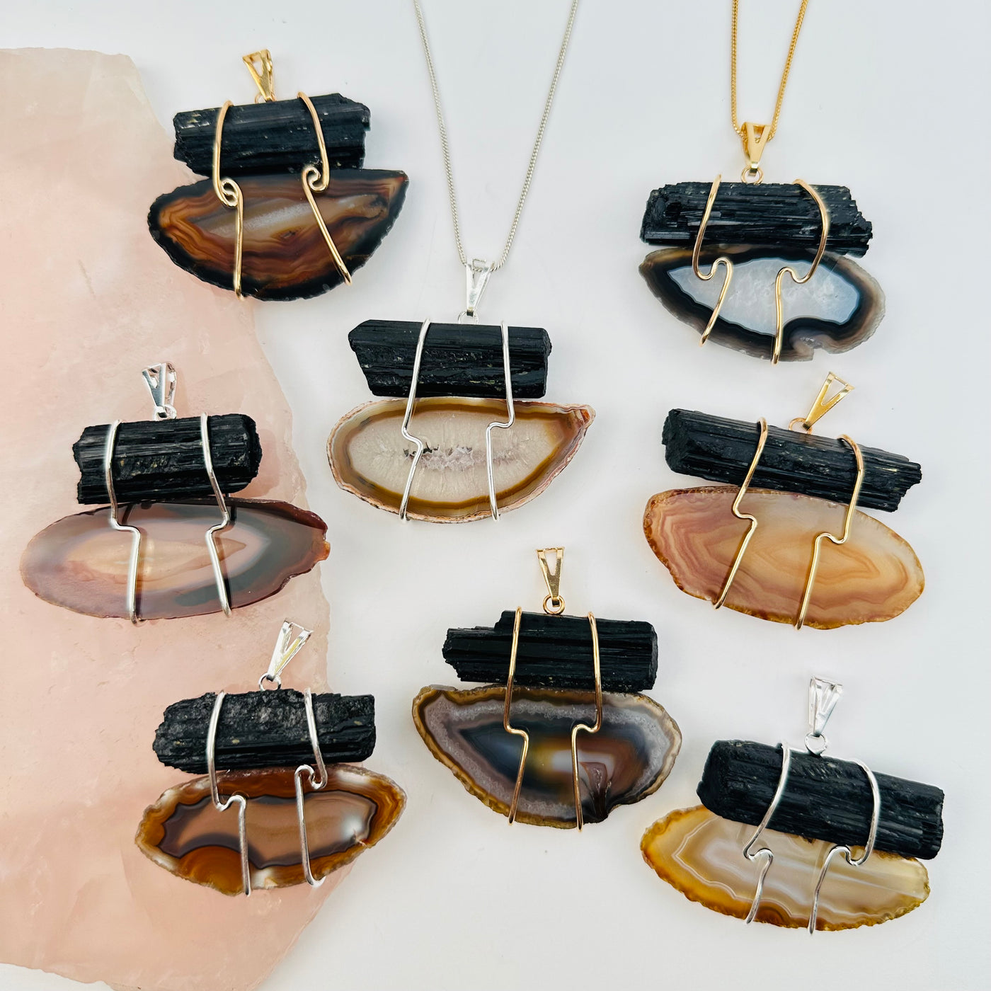 multiple tourmaline and agate slice wire wrapped pendants displayed to show the differences in the sizes and color shades 